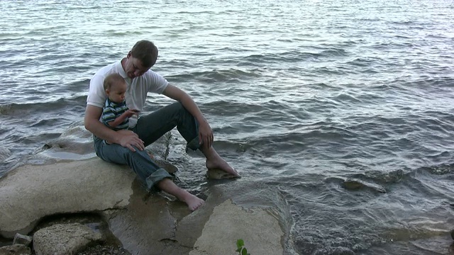 父亲和儿子在水边玩耍视频下载