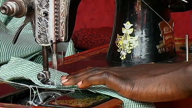 中镜头妇女在缝纫机上工作/放大近距离机器/缩小妇女缝纫/加纳视频下载