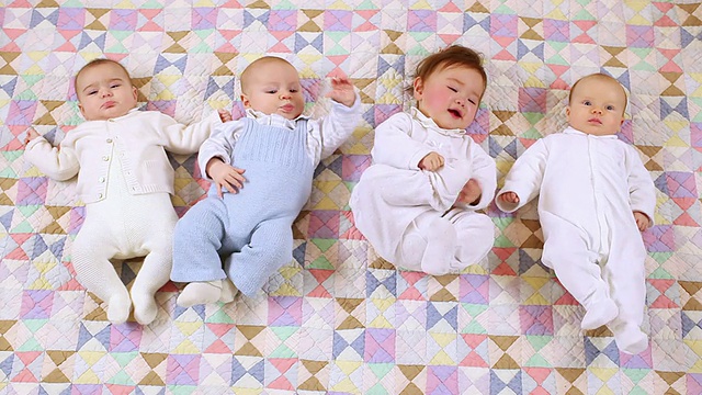4个婴儿(6-11个月)躺在布料上，比利时布鲁塞尔视频素材