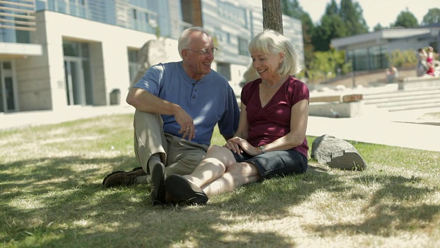 一对老年夫妇坐在公园的草坪上聊天，加拿大不列颠哥伦比亚省视频下载