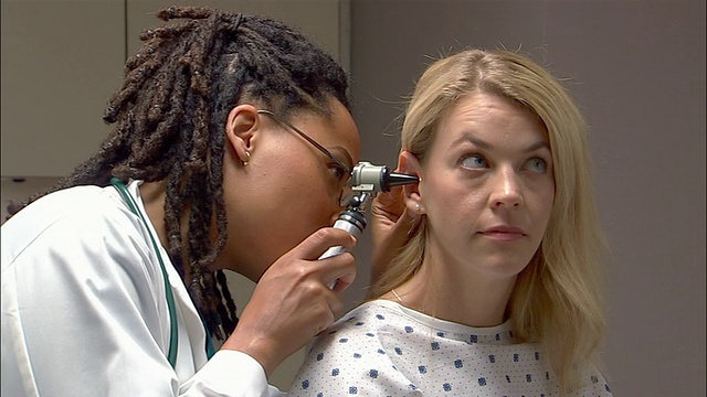 医生用耳镜检查妇女的耳朵视频素材
