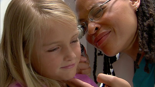 医生用耳镜检查小女孩的耳朵视频素材