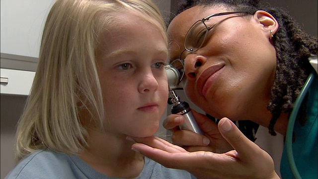 医生用耳镜检查小男孩的耳朵视频素材