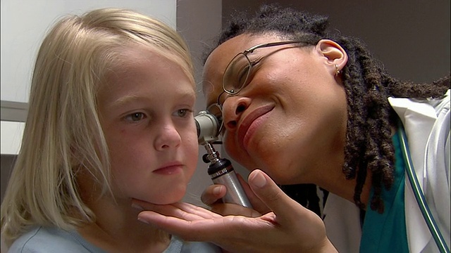 医生用耳镜检查小男孩的耳朵视频素材