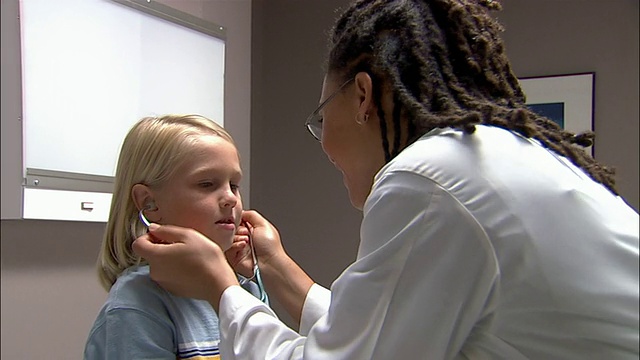中枪医生让病人用听诊器听她的心跳/医生听男孩的心跳视频素材