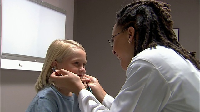 中枪医生让病人用听诊器听她的心跳/医生听男孩的心跳视频素材