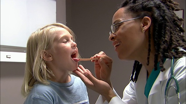中枪医生检查小男孩的嘴和喉咙视频素材