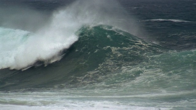 在夏威夷瓦胡岛北岸的风暴中，当它在海滩上破裂时，膨胀卷曲并喷出浪花视频下载