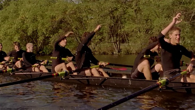 中镜头侧视图摇摄赛艇队在查尔斯河赛艇/停止赛艇和互相祝贺视频素材