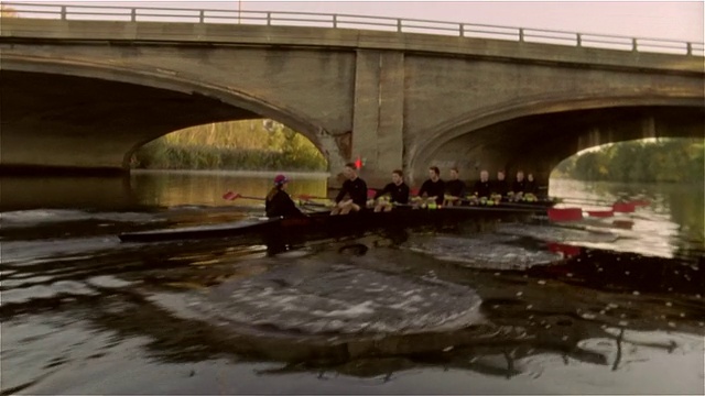 在查尔斯河的一座桥下，中速赛艇队赛艇视频素材