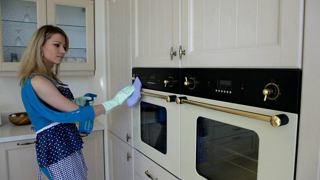 女人在厨房里清理烤箱视频素材