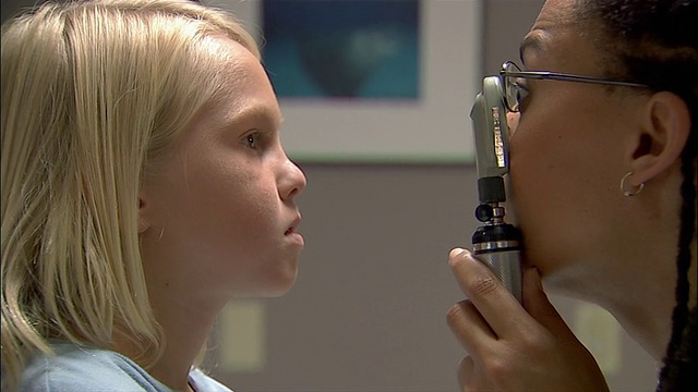 医生用眼科镜仔细检查小男孩的眼睛视频素材