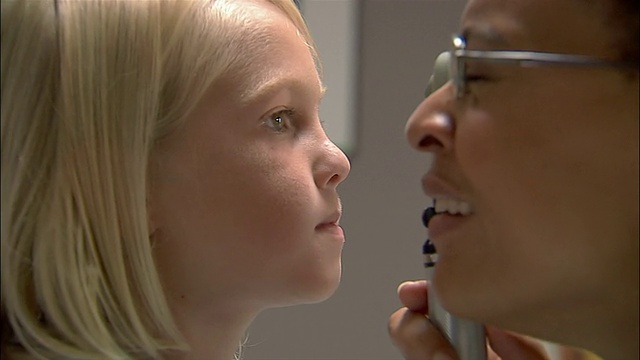 医生用眼科镜仔细检查小男孩的眼睛视频素材