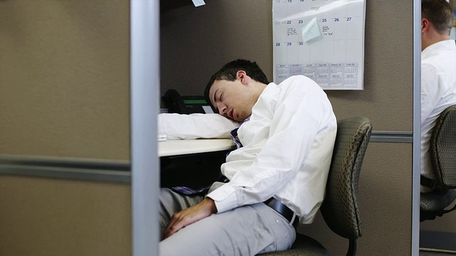 一个疲倦的男人睡在办公室的桌子上，美国犹他州Orem视频下载