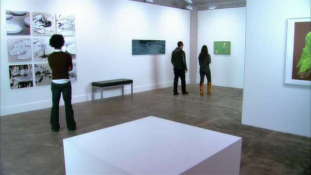 画廊工作人员与一对夫妇握手，离开去看艺术品视频下载