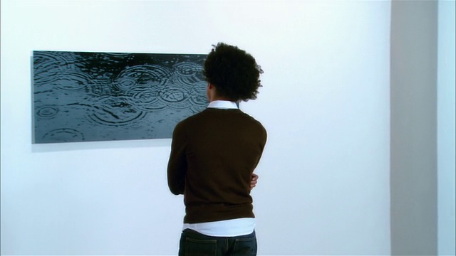 在当代艺术展览上，年轻人看艺术品的后视图视频下载