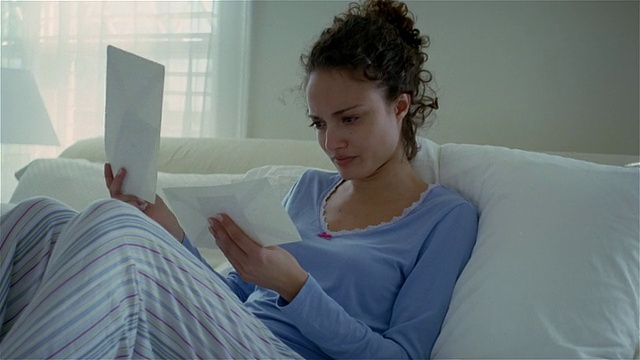 中枪病女人坐在床上，阅读邮件/索尔伯里，宾夕法尼亚州视频下载
