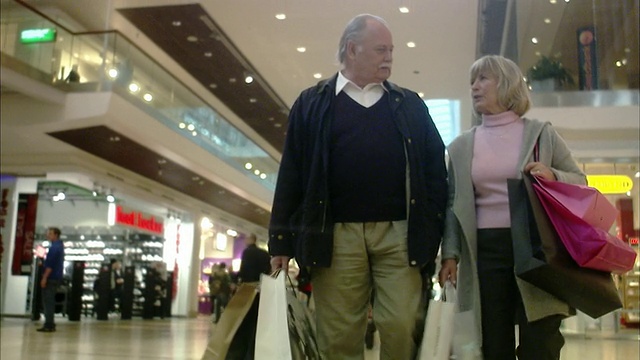 一对老年夫妇提着购物袋，瑞典斯德哥尔摩。视频素材