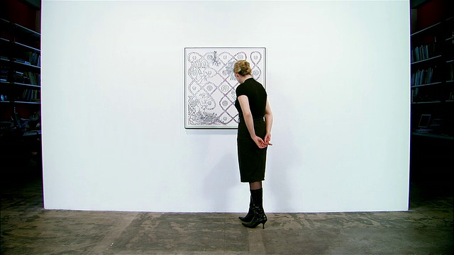 一个女人在看挂在画廊墙上的画视频下载