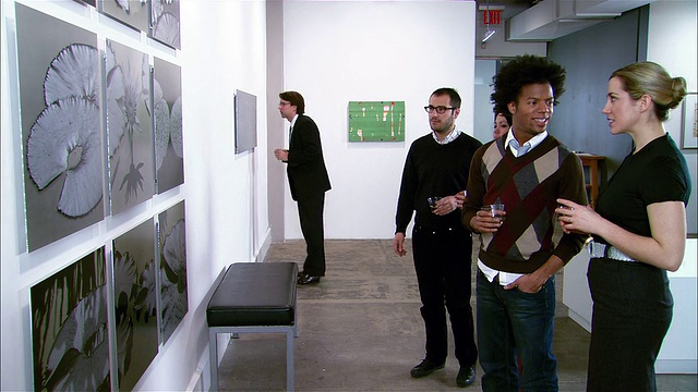 人们在画廊开幕时看墙上的艺术品视频下载