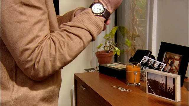 男人在早上准备/戴上手表，从抽屉里拿起眼镜视频素材