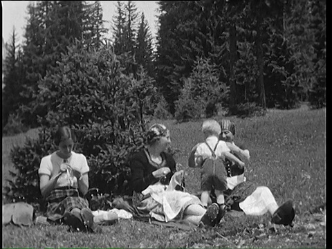 1937年，德国巴伐利亚，母亲和孩子们在山地草地上休息视频下载