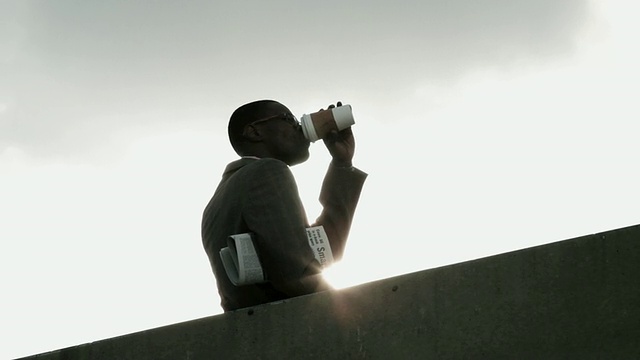 商人用一次性杯子靠墙喝，角度低视频素材