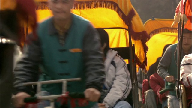 中镜头一排载着乘客的三轮车向镜头/北京移动视频下载