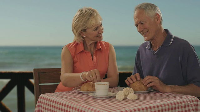 一对老年夫妇在海边咖啡馆见面，服务生端咖啡视频下载