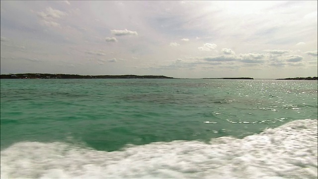 侧船眺望碧水下阴天与远处岛屿视频下载