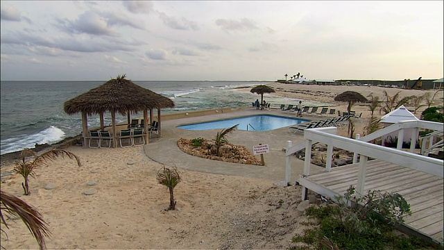 宽镜头平移海滩和池畔地区在度假村/阿巴科，巴哈马视频下载