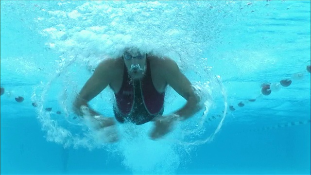 低角度水下视图游泳者做蝶泳向相机视频下载