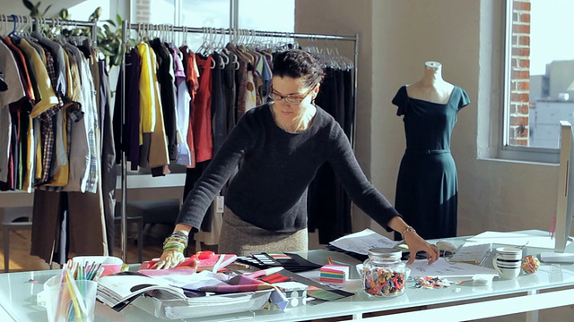 MS时装设计师整理织物样本在办公桌/纽约，纽约，美国视频素材
