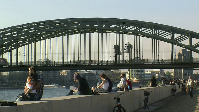 德国北莱茵-威斯特伐利亚州科隆，坐在霍亨索伦大桥旁眺望莱茵河的人们视频下载