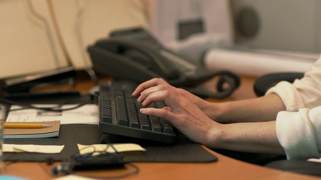 特写镜头倾斜的女商人在电脑键盘上打字，面对着镜头视频素材