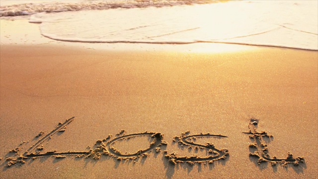 “迷失”这个词写在日落时分的海滩上视频下载