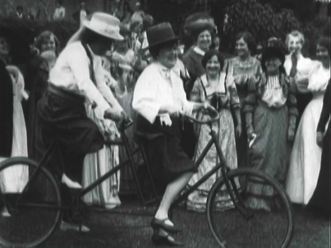 重现维多利亚时代的男人和女人在街道上散步和骑双人自行车/洛杉矶，加利福尼亚，美国视频下载