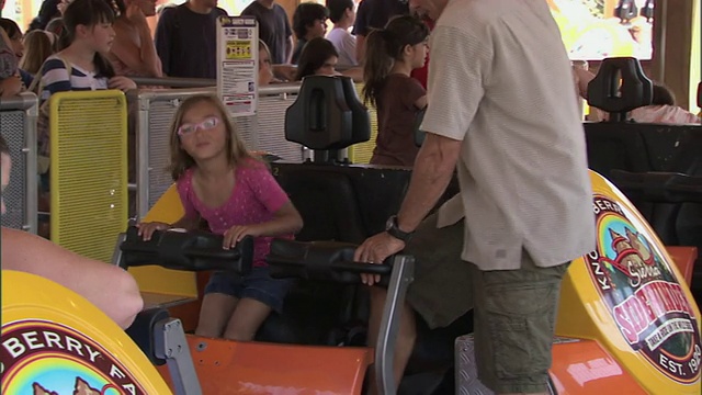 小女孩和父亲坐在诺特浆果农场的响尾蛇过山车上视频素材