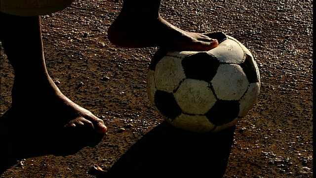 南非开普敦，豪特湾，赤足男孩在足球上抱着脚视频素材
