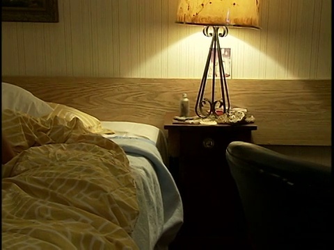 中等镜头的年轻女子跪在汽车旅馆房间的床上视频下载