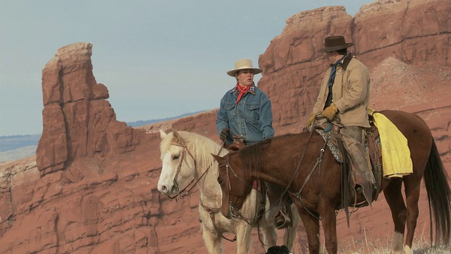 MS牛仔和女牛仔坐在马背上聊天在风景秀丽的山顶/壳牌，怀俄明州，美国视频下载