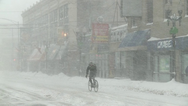 在暴风雪中骑自行车的人/芝加哥，伊利诺伊州，美国视频下载
