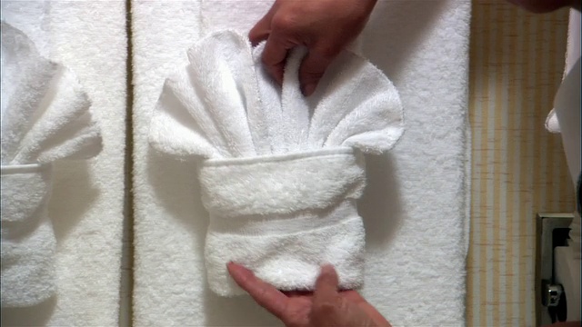 CU, PAN，在酒店浴室里整理毛巾的女人，手的特写视频下载