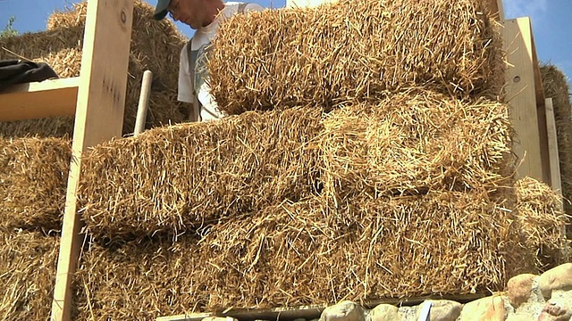 MS ZO CS Carpenter在美国密歇根州草地湖的一个节能柱子框架中围绕着稻草捆工作视频下载