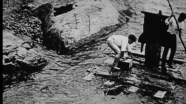 1914 B/W中枪两名男子在木筏上从河岸上推挤视频下载
