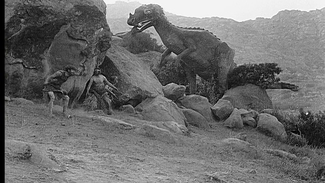 1914 B/W广角镜头恐龙在洞口吃东西，恐吓穴居人视频素材