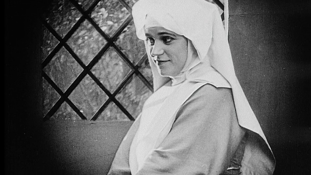 1916年B/W中拍摄年轻的修女望着窗外微笑视频素材