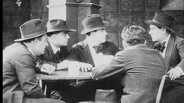 1916年B/W中镜头一群人围坐在桌子旁谈天说地视频素材