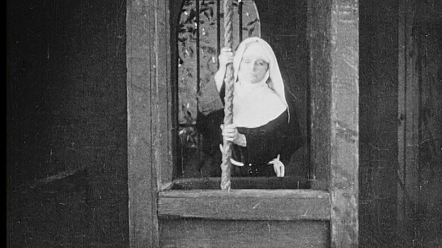1916年黑白蒙太奇中景——特写修女在钟楼/教堂钟声中拉绳子视频素材