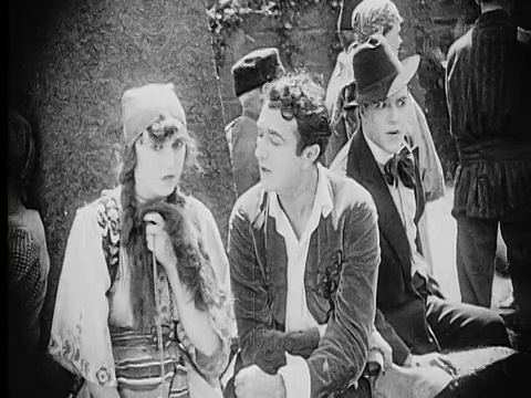 1916年B/W中拍摄了一名男子和一名女子在城市广场交谈，而邪恶的男子在偷听视频素材